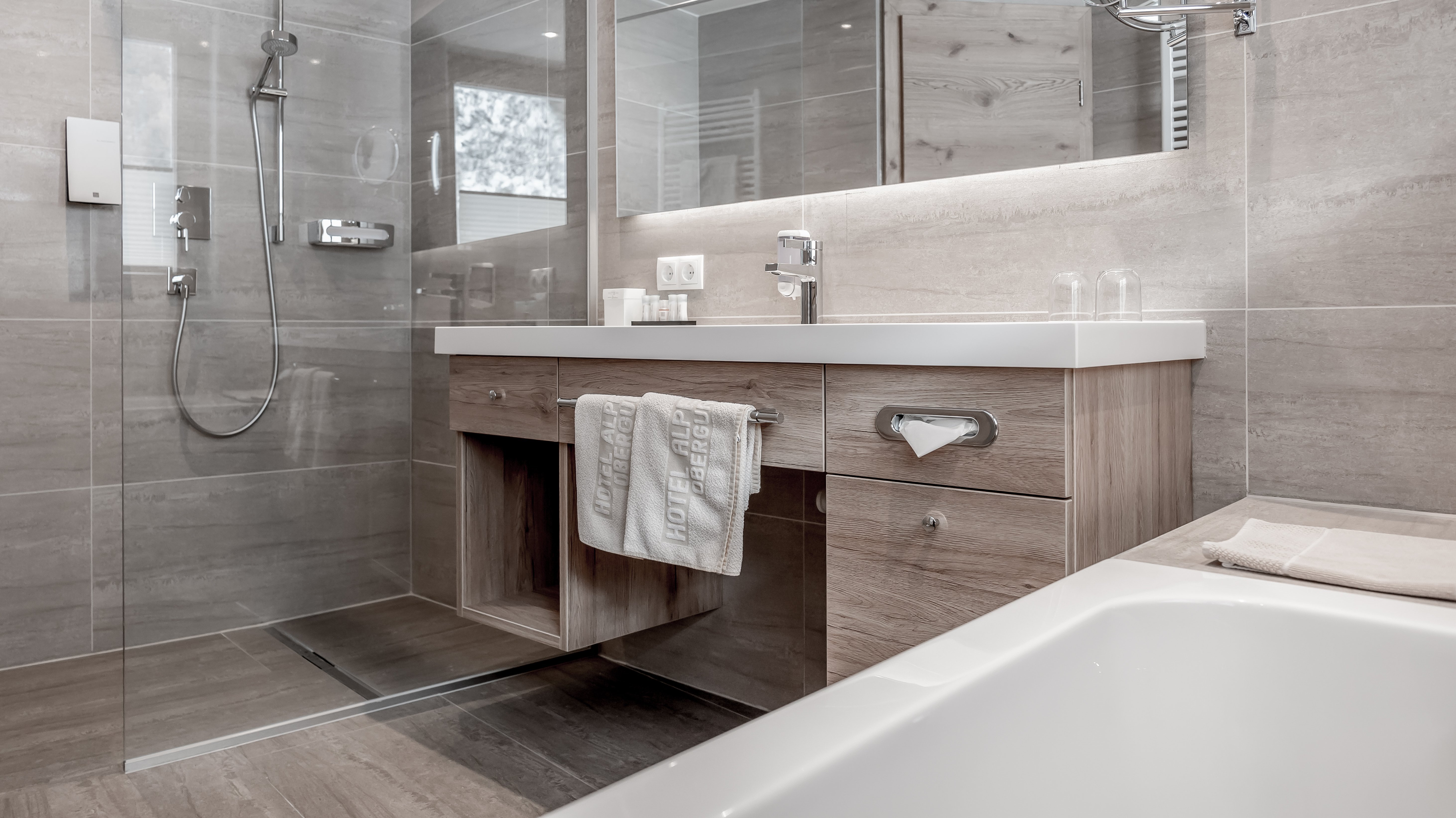 Modernes Badezimmer mit eleganten Details Helles modernes Badezimmer mit Glasdusche, Holz-Waschbecken und Badewanne ohne sichtbare Farben.