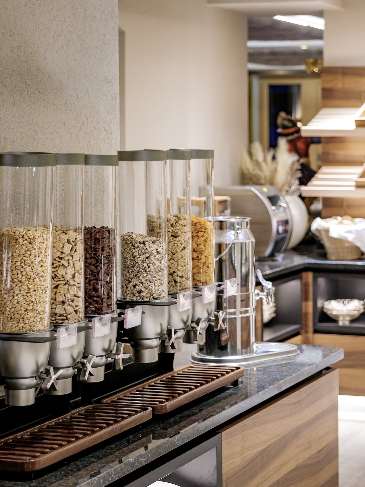Frühstückserlebnis im Hotel Alpenland Buffetbereich mit Müsli-Spendern und Holzservierstation im Hotelrestaurant am Frühstücksbuffet.
