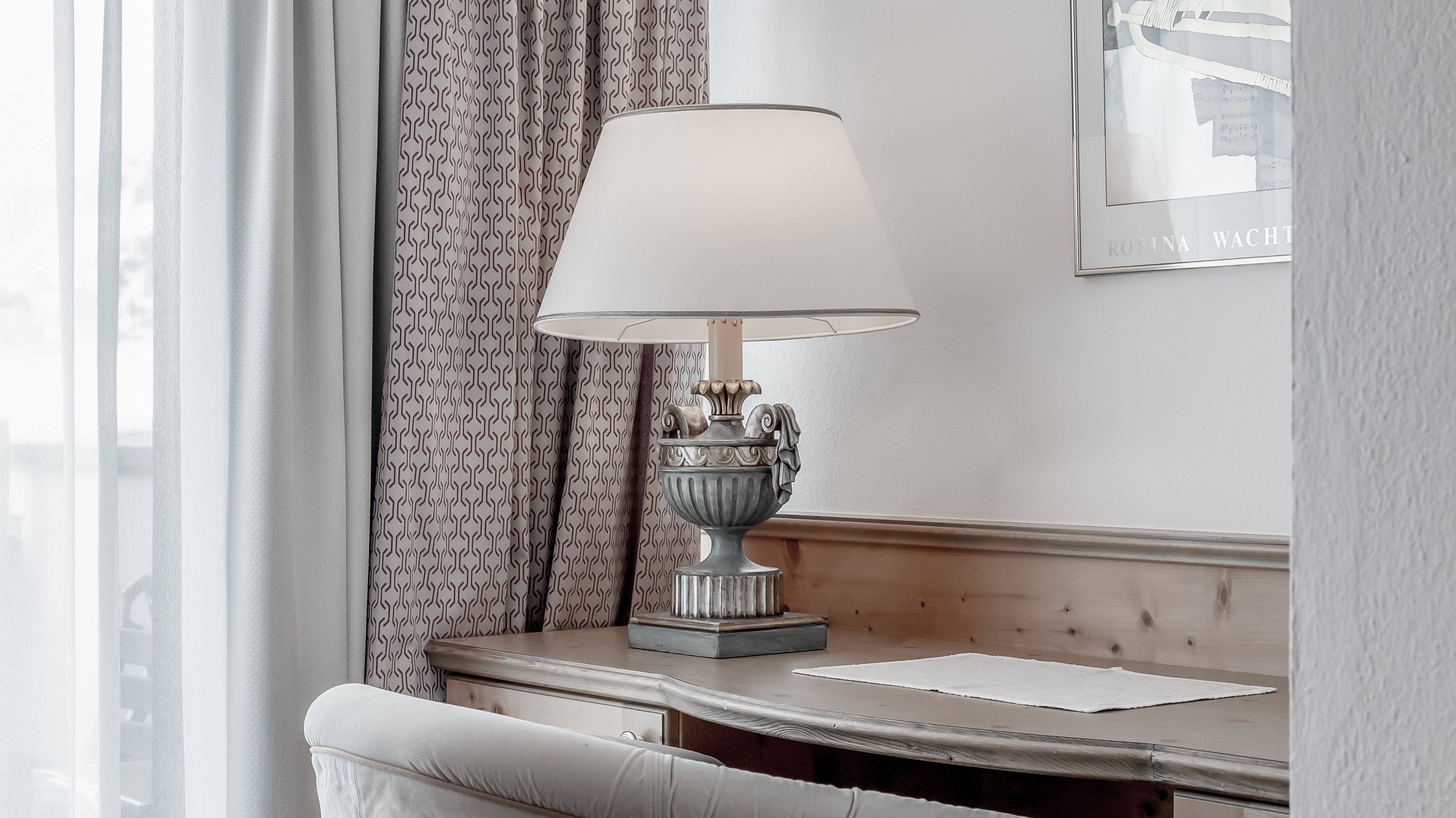 Modernes Home Office mit gemütlichem Flair Ein heimisches Arbeitszimmer mit Schreibtisch, Stuhl und Lampe sowie Vorhängen im Hintergrund.