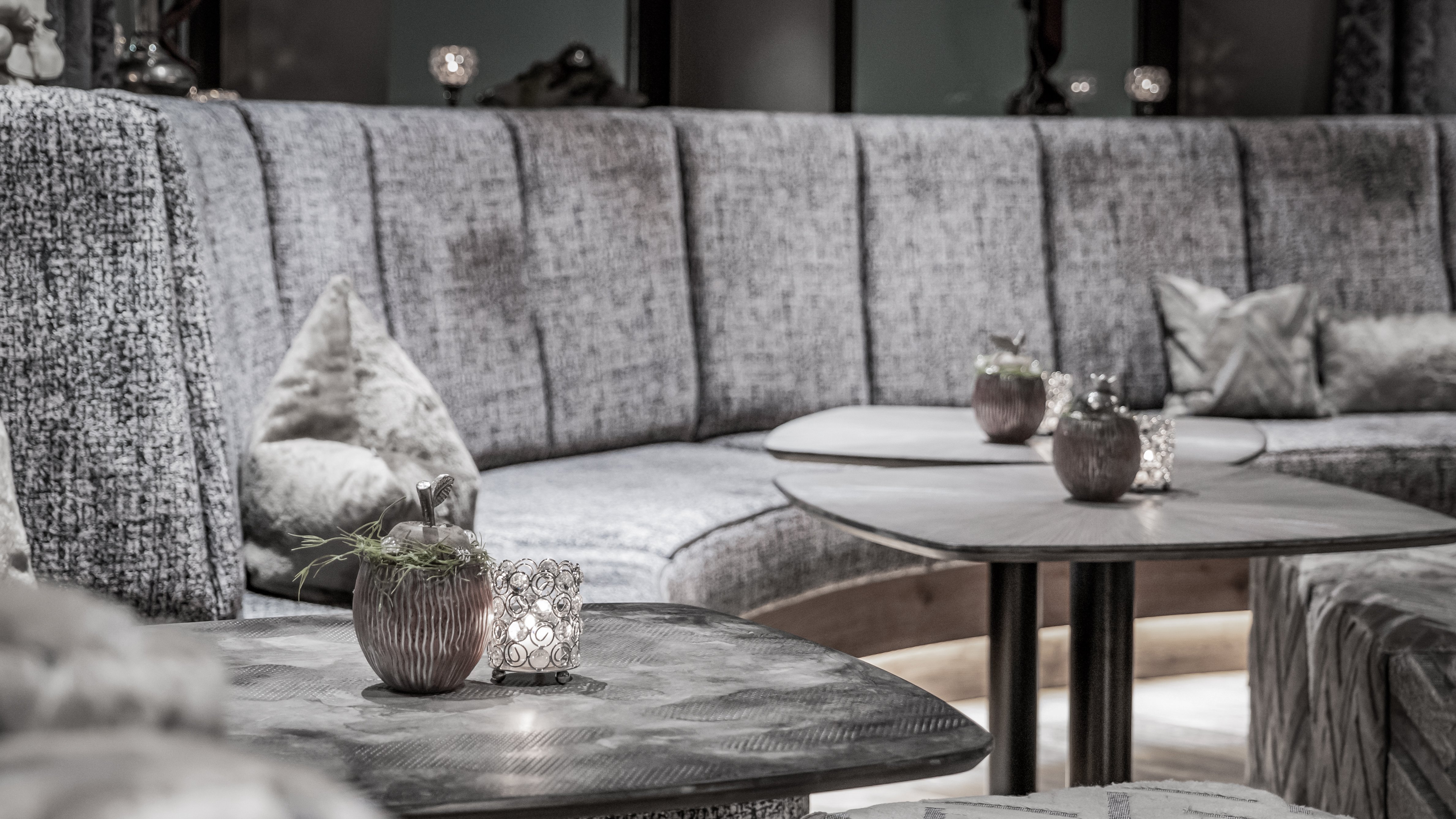 Moderne Lounge mit geschwungenen Sitzmöbeln und kleinen Tischen in einem eleganten Design