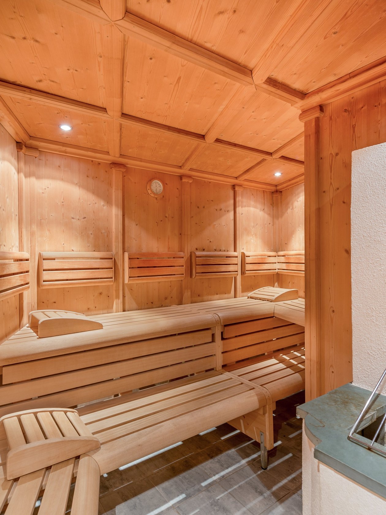 Wohlfühloase in der Sauna Innenansicht einer Holzsauna mit Bänken und einem Ofen zur Entspannung und Erholung.