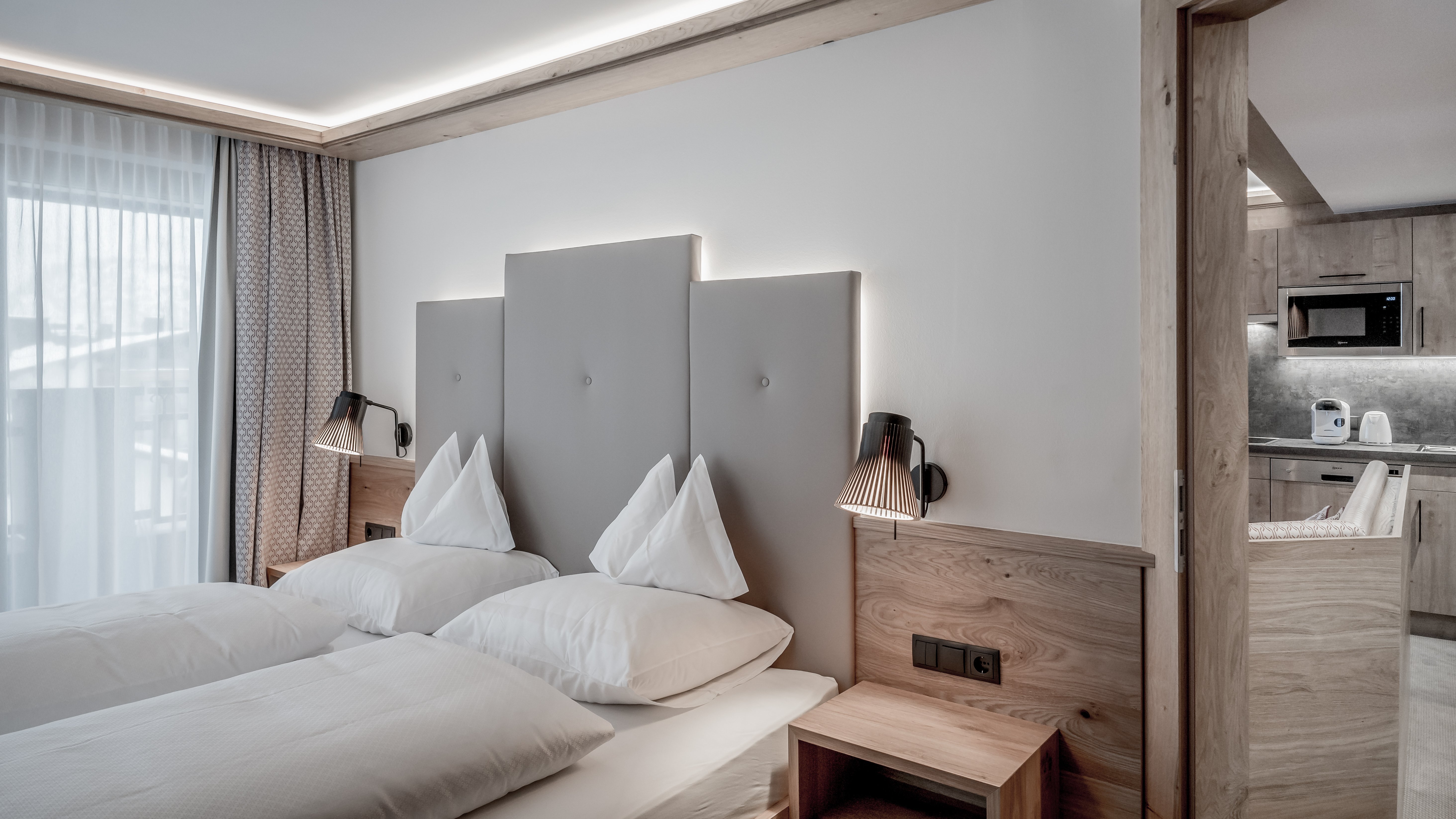Moderne Eleganz im Schlafzimmer Helles Hotelzimmer mit zwei Betten, Holzverkleidung und stilvollem Lichtkonzept.