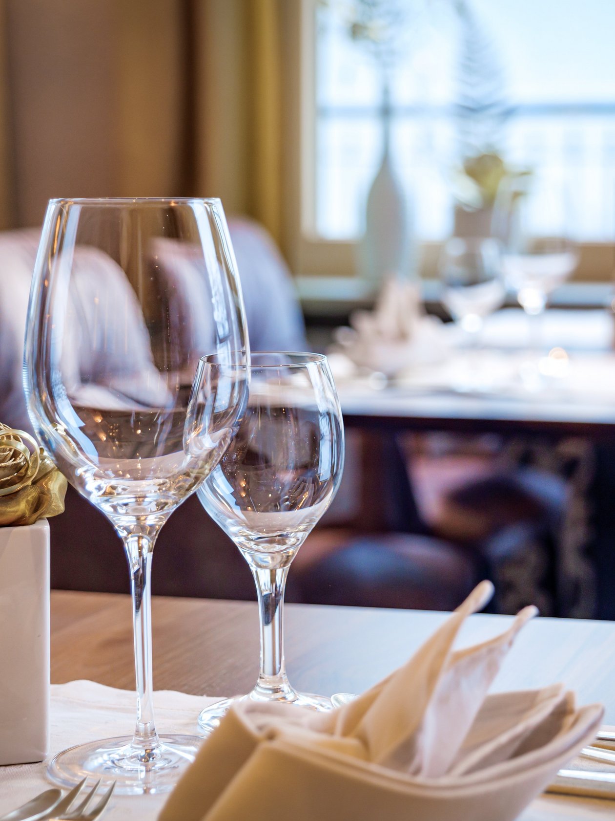 Elegante Tischgestaltung im Hotel Alpenland Ein stilvoll gedeckter Tisch mit Gläsern und Besteck im Restaurantbereich. 1-930m über dem Meeresspiegel.