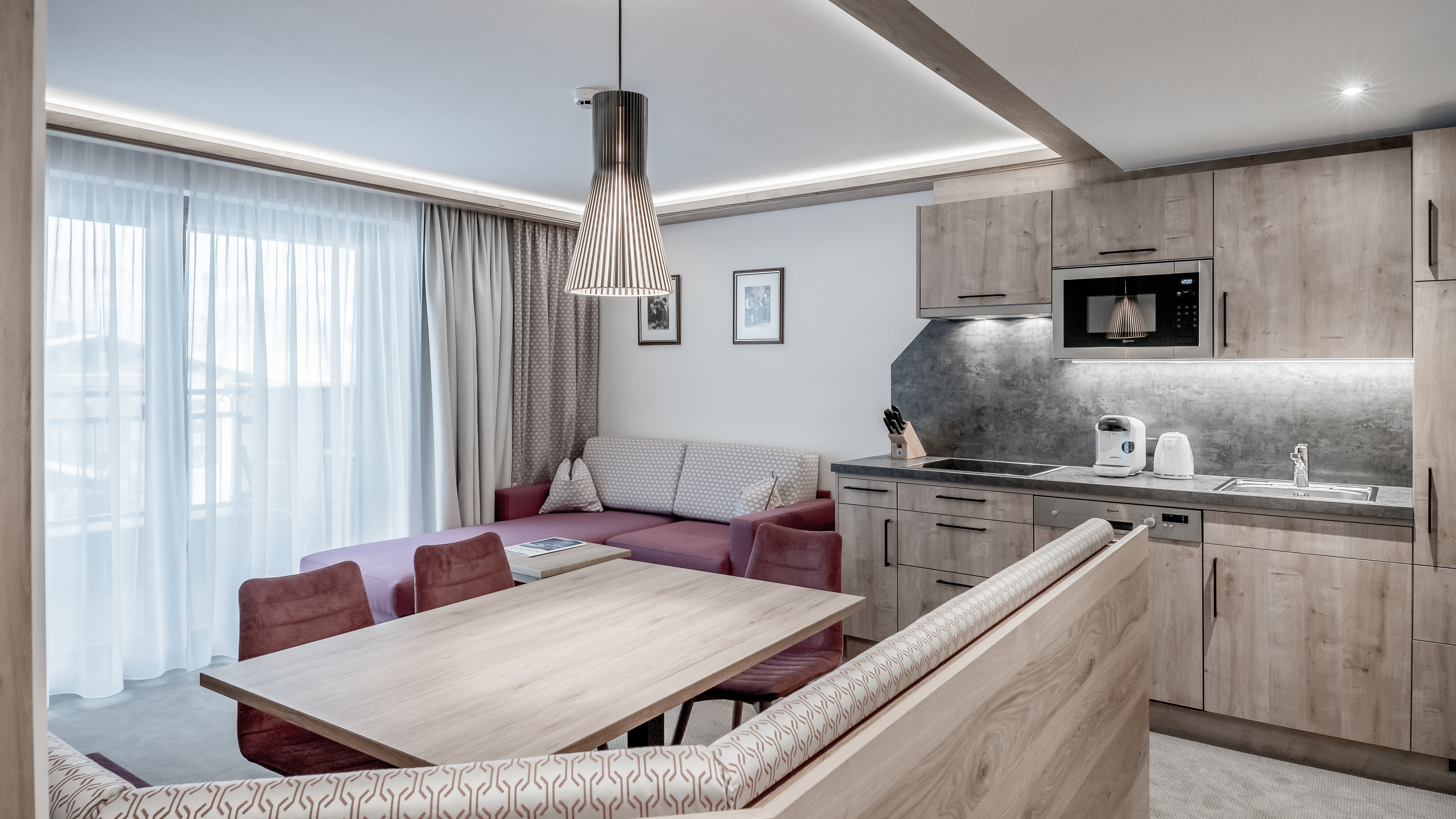 Moderne Wohnung mit Wohnzimmer und Küche Wohnbereich einer modernen Wohnung mit Sofa, Esstisch und Küchenzeile im Hintergrund.
