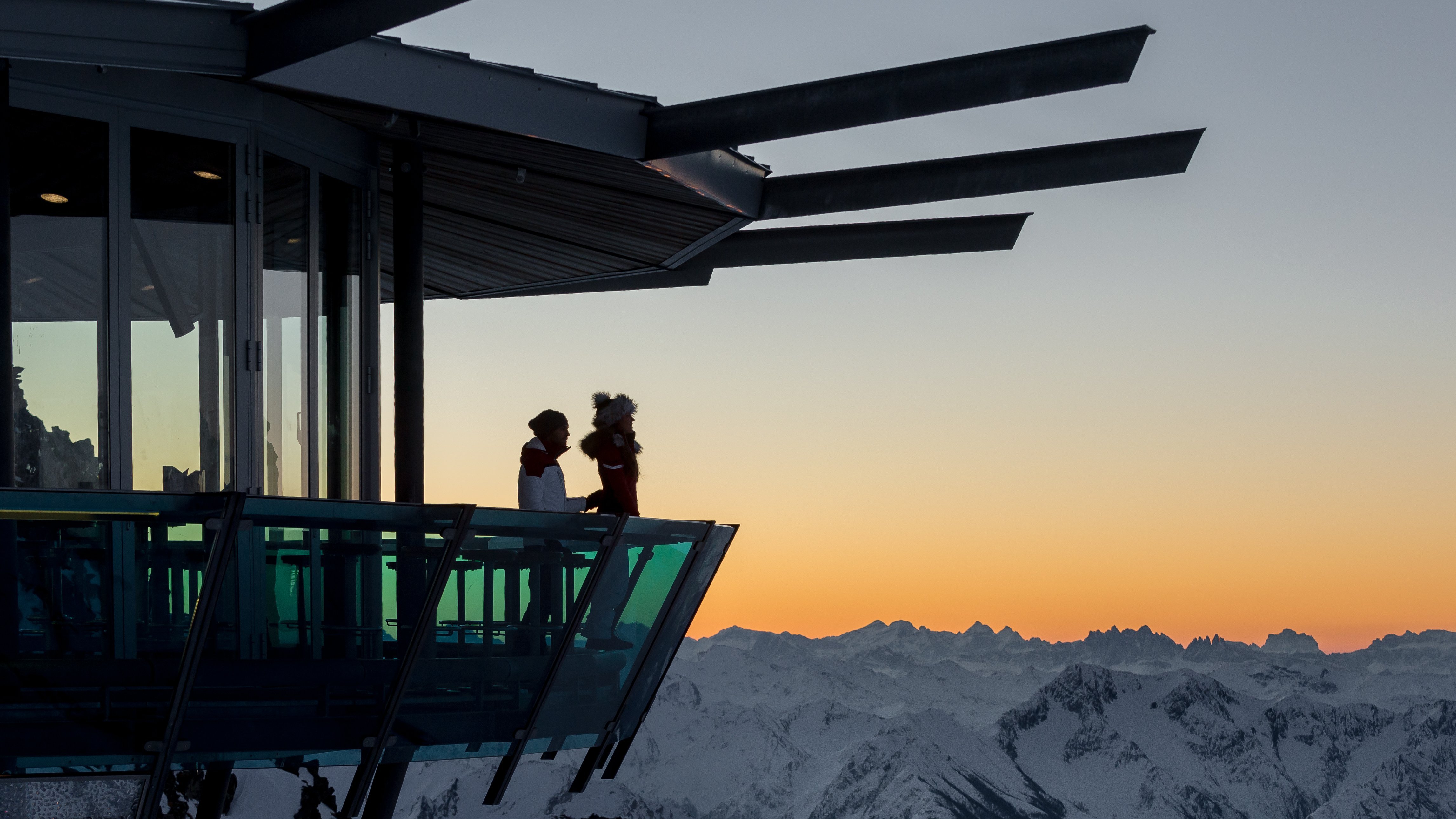 Bergblick bei Sonnenuntergang Silhouette von zwei Personen auf einer Aussichtsplattform mit Bergsicht während des Sonnenuntergangs