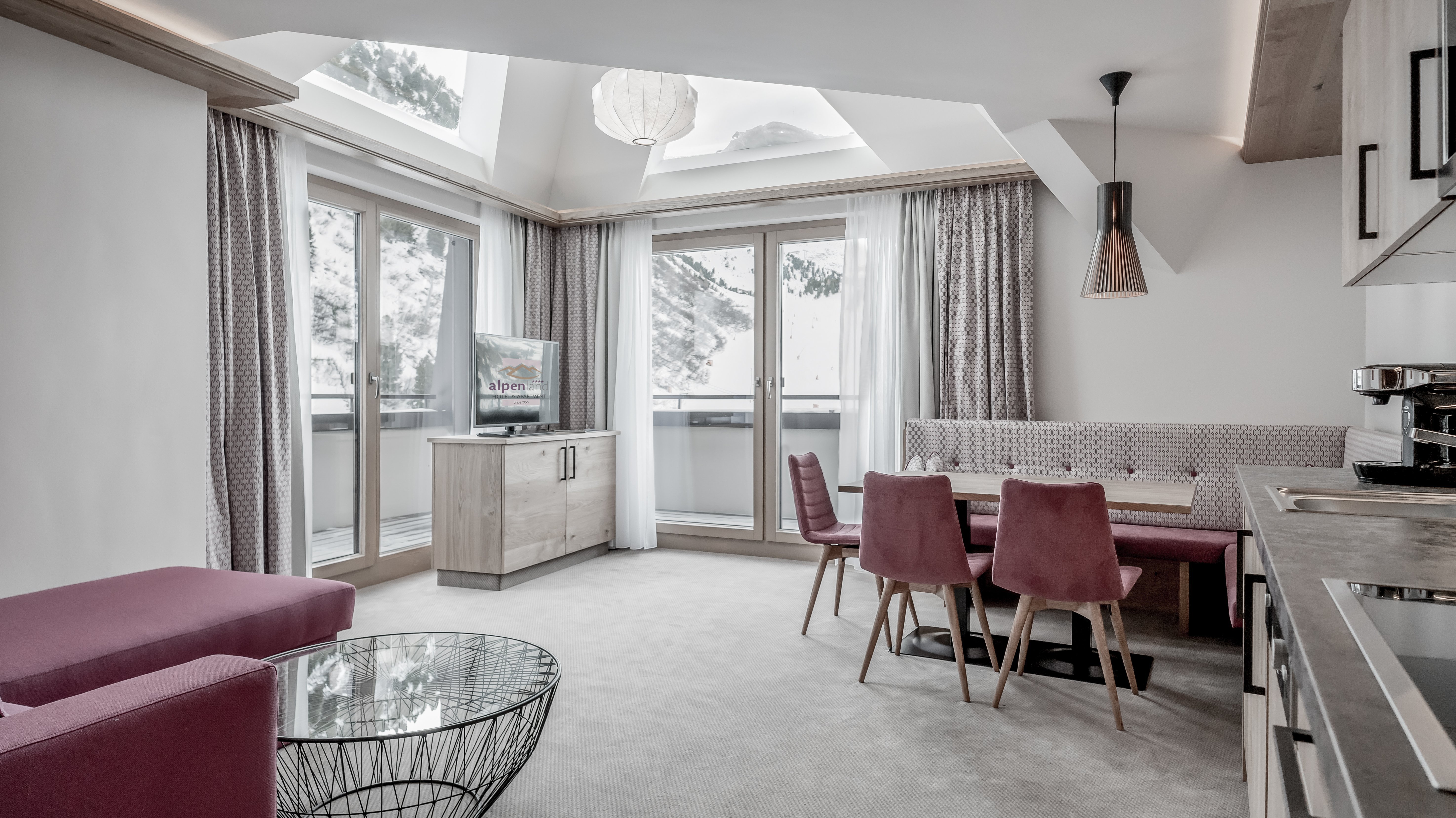 Moderne Wohnlandschaft im Superior Apartment Gemütlicher Wohnbereich mit großen Fenstern und modernem Mobiliar in einem Skiresort-Apartment.