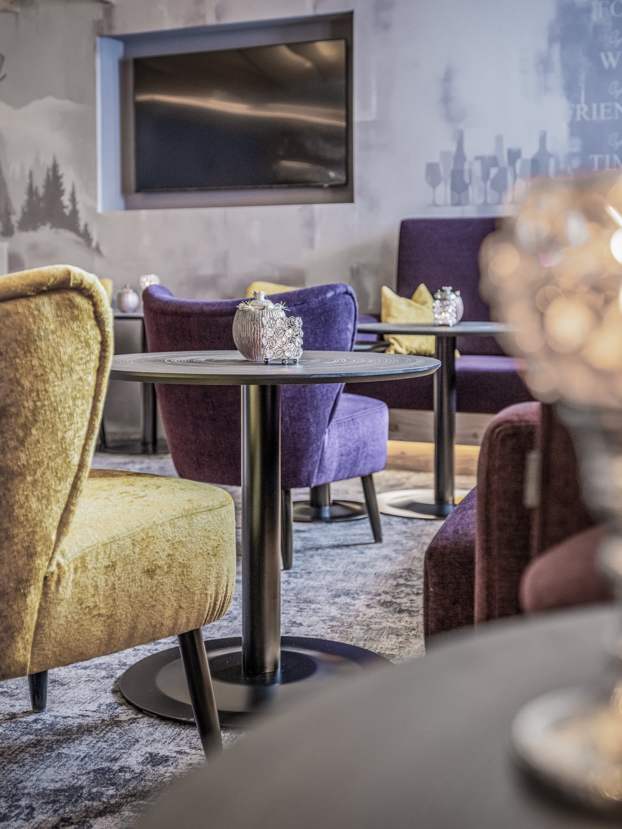 Loungebereich mit bunten Stühlen und Tischen im modernen Stil und sanfter Beleuchtung.