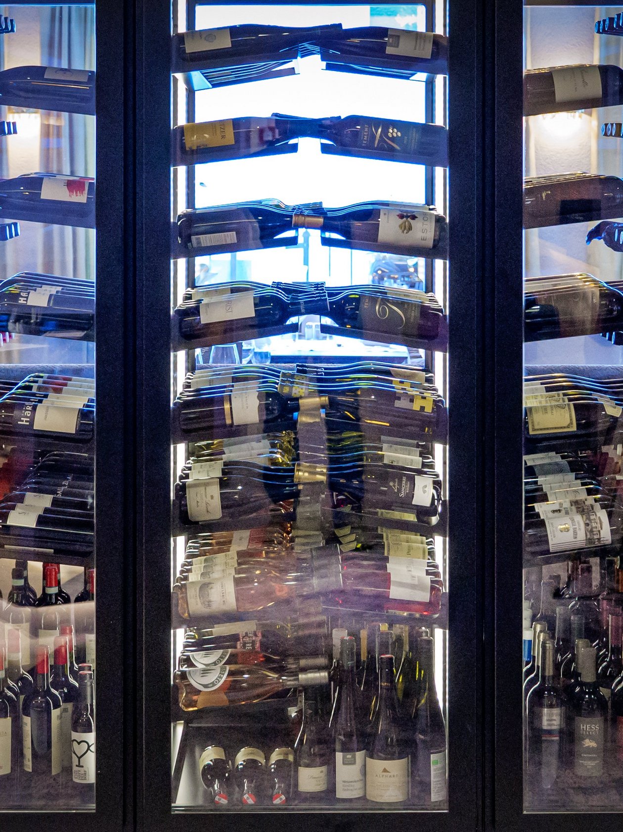Exquisite Wine Storage A large glass-fronted wine rack filled with various bottles of wine arranged for display.