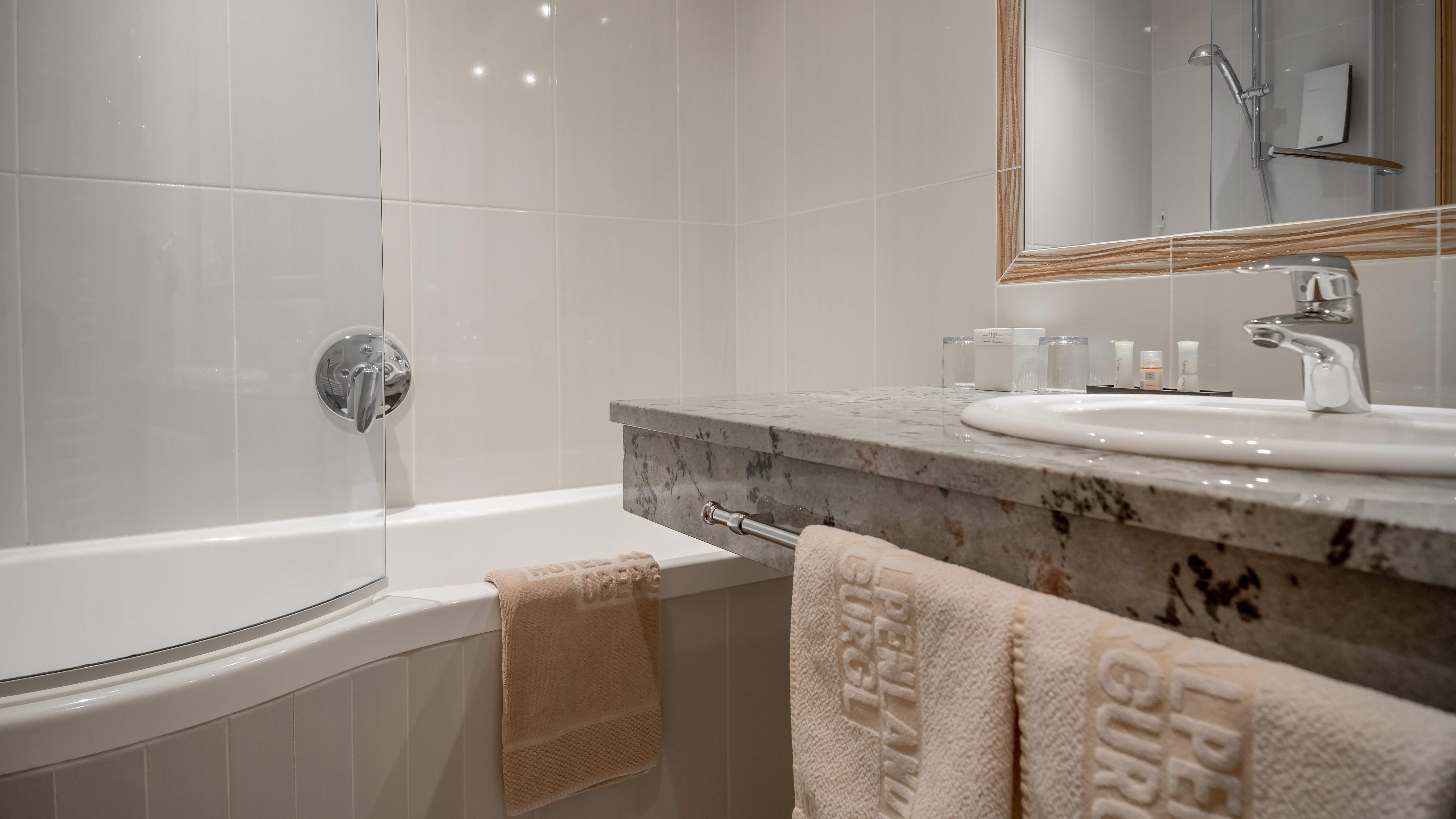Schön gestaltetes Badezimmer mit Dusche, Badewanne und Handtüchern auf einem modernen Waschtisch