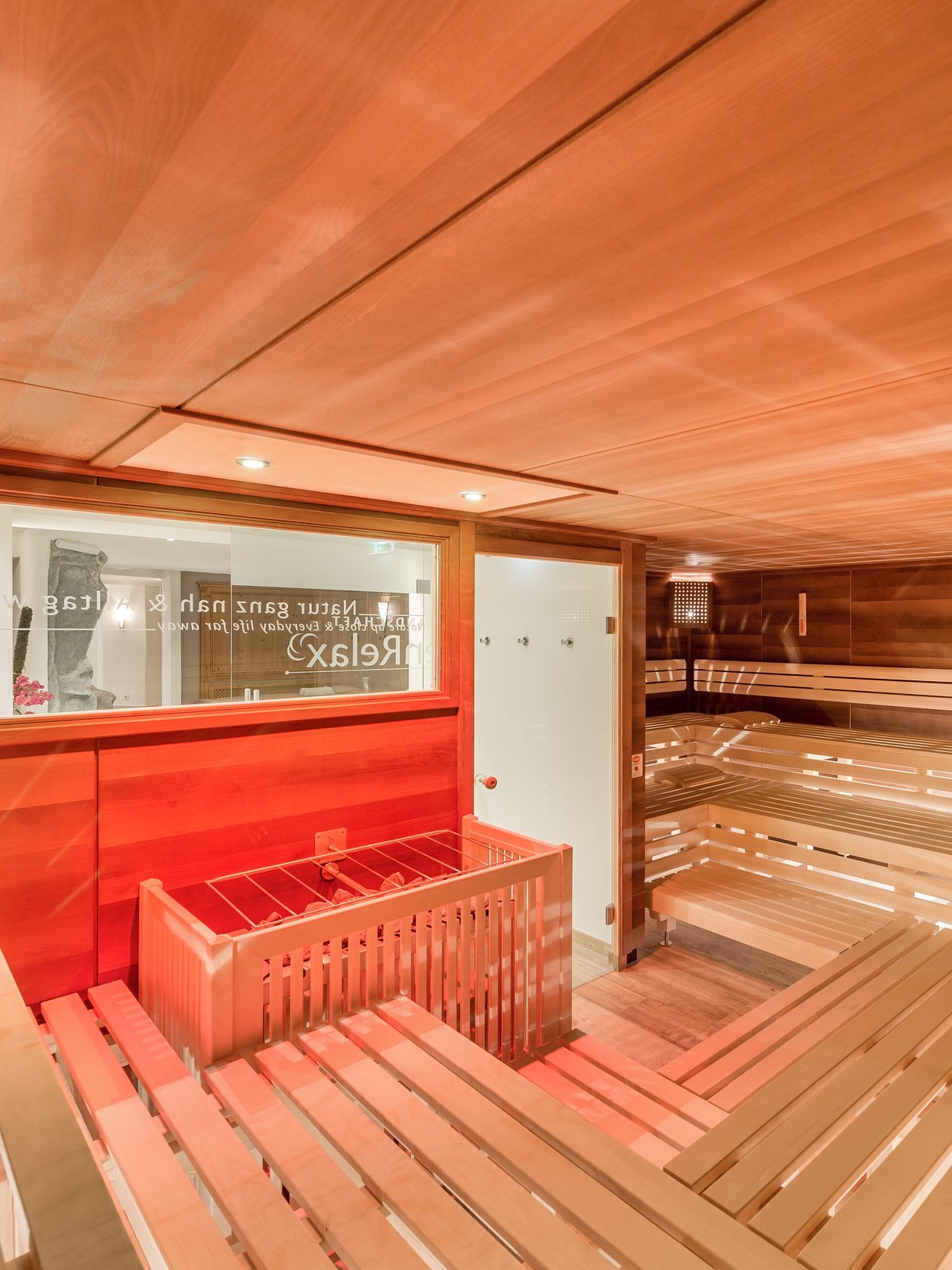 Interior der Sauna mit Holzbank und warmem Licht zur Entspannung gestaltet. Keine Personen sichtbar.