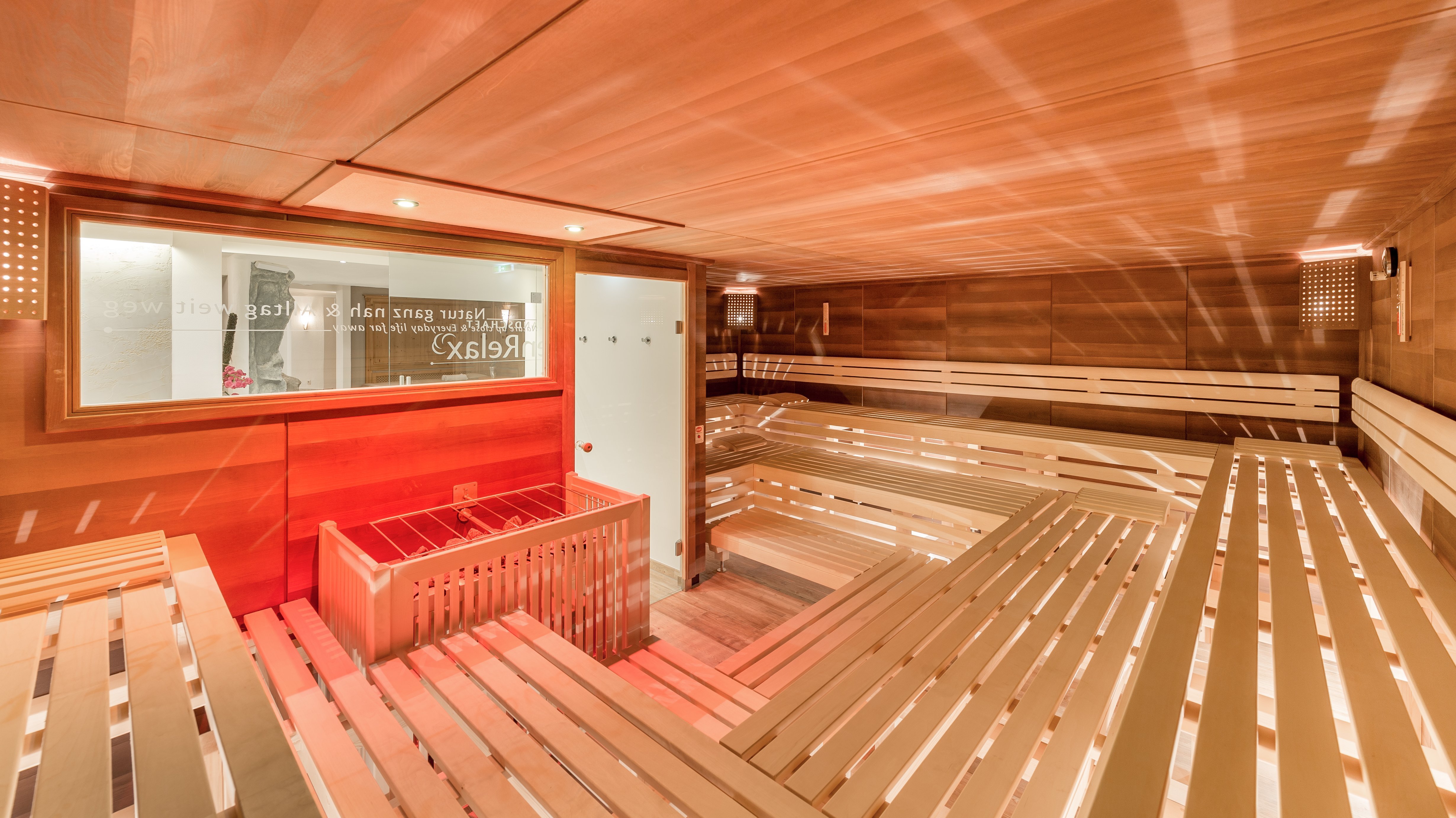 Interior der Sauna mit Holzbank und warmem Licht zur Entspannung gestaltet. Keine Personen sichtbar.