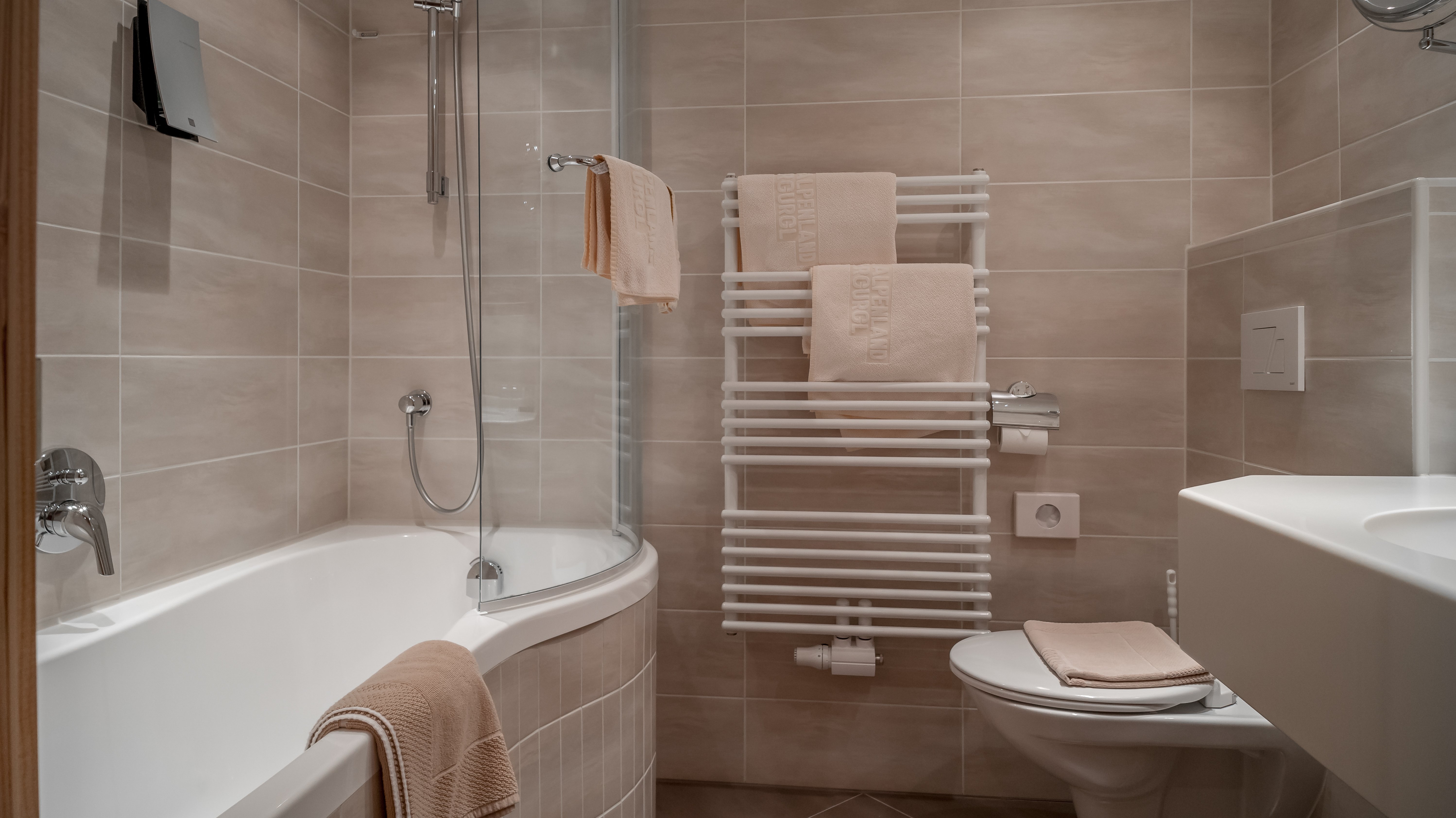Moderner Badezimmerstil für Ihr Wohlbefinden Modernes Badezimmer mit Badewanne, Dusche, Handtuchhalter und Waschbecken im minimalistischen Stil.