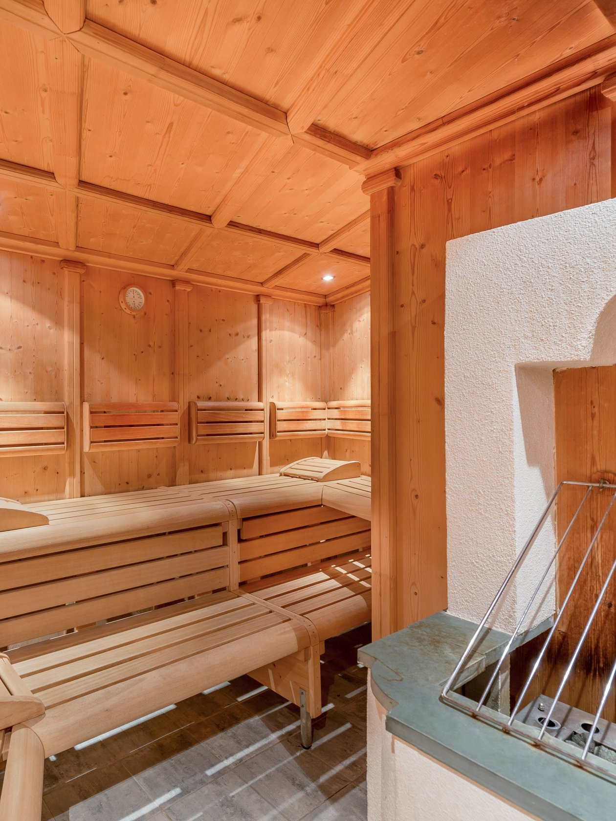 Holzsauna für Entspannung Innenansicht einer Sauna mit Holzbänken und einem Heizgerät, die zum Relaxen einlädt.