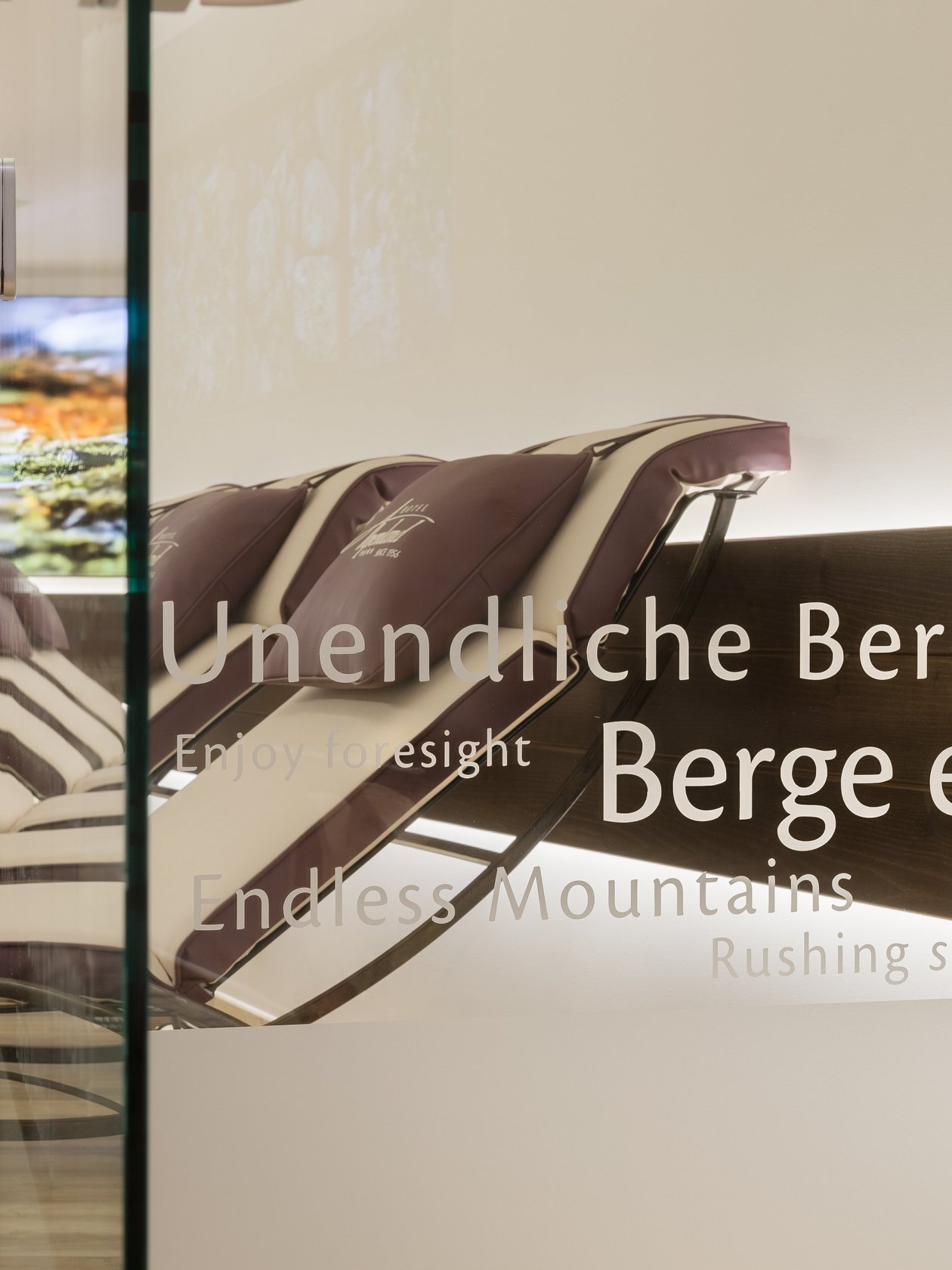 Ruhige Wellness-Oase mit Liegen und Bergmotiv im Hintergrund zur Entspannung und Erholung.