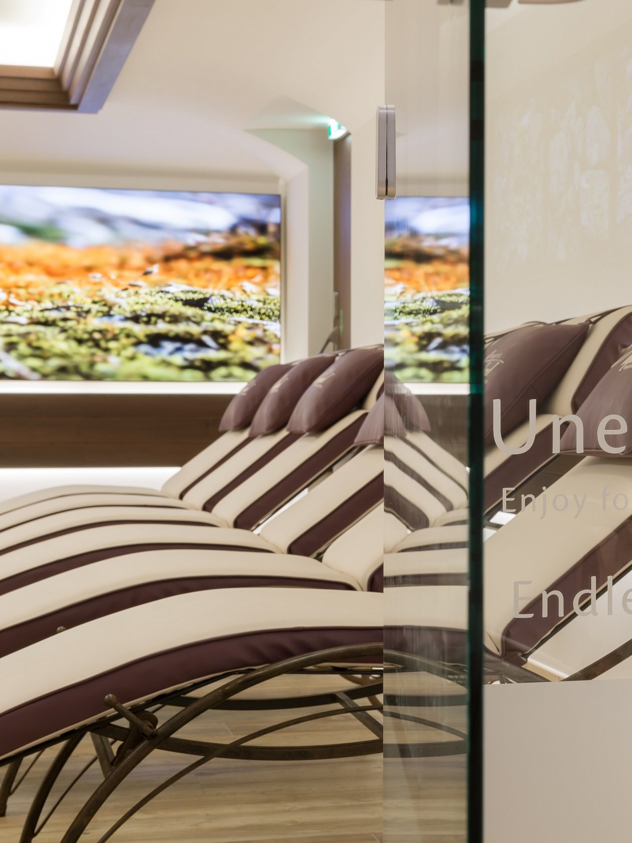 Ruhige Wellness-Oase mit Liegen und Bergmotiv im Hintergrund zur Entspannung und Erholung.