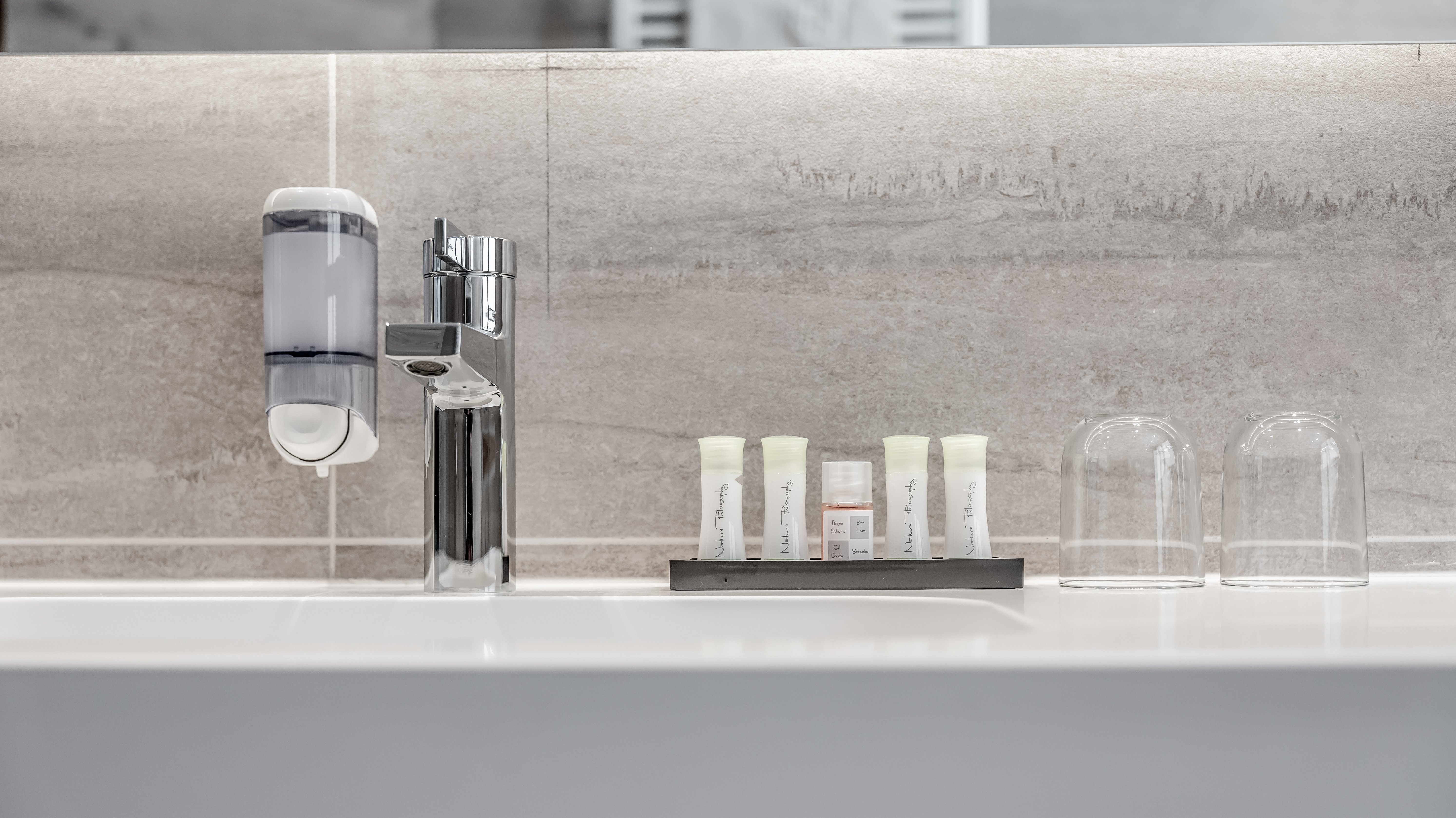 Modernes Badezimmerdesign im Alpenland Ein minimalistisches Badezimmer mit einem modernen Waschbecken und einem eleganten Wasserhahn.